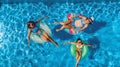 Aerial top view of family in swimming pool from above, mother and kids swim on inflatable ring donuts and have fun in water Royalty Free Stock Photo