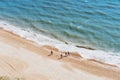 Aerial Top view family walking on the beach on a sunny day. Calming and enjoying life. Emotional wellness. Happiness is
