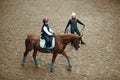 Aerial, top view. Female teacher, instructor teaching little girl, kid horseback riding. Careful ride, outdoor lesson Royalty Free Stock Photo