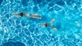 Aerial top view of girls in swimming pool water from above, active children swim, kids have fun on tropical family vacation