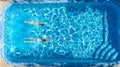 Aerial top view of girls in swimming pool water from above, active children swim, kids have fun on tropical family vacation Royalty Free Stock Photo
