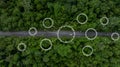 Aerial top view of green electric vehicle car driving over straight forest road, EV car electric vihicle car on forest road with