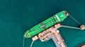 Aerial top view of green oil tanker cargo vessel under cargo ope