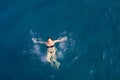 Aerial top view happy young woman in black swimsuit swims in the Red Sea, Egypt, Sharm el Sheikh. Vacation and adventure Royalty Free Stock Photo