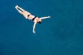 Aerial top view happy young woman in black swimsuit swims in the Red Sea, Egypt, Sharm el Sheikh. Vacation and adventure Royalty Free Stock Photo