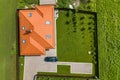 Aerial top view of house shingle roof with attic windows and black car on paved yard with green grass lawn Royalty Free Stock Photo