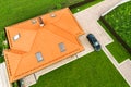 Aerial top view of house shingle roof with attic windows and black car on paved yard with green grass lawn Royalty Free Stock Photo