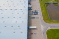 Aerial Top View of Industrial Storage Building Area with Solar Panels on the Roof and Many Trucks Unloading Merchandise Royalty Free Stock Photo