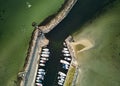 Aerial top view of Kulhuse harbor, docked sailing boats, breakwater extended in the water, Denmark