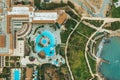 Aerial top view of little hotel with swimming pool, sunbeds and palms from above, tropical holiday resort, mediterranean