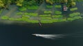 aerial top view motion blur long tail boat full speed and spash water line in the riverside and morning glory with small farmer Royalty Free Stock Photo