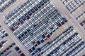 Aerial top view new cars lined up in the port for import export business logistic and transportation by ship in the open sea. New