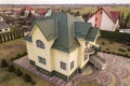 Aerial top view of new residential house cottage with shingle roof on fenced big yard on sunny day