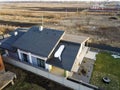 Aerial top view of new residential house cottage and terrace with shingle roof on fenced big yard on sunny winter day Royalty Free Stock Photo