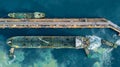 Aerial top view oil tanker ship at terminal industrial port tugboat drag crude oil tanker ship park to port for transfer crude oil Royalty Free Stock Photo