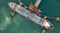 Aerial top view oil tanker ship at oil terminal industrial port tugboat drag oil ship tanker park to port for transfer crude oil