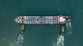 Aerial top view oil tanker ship at oil terminal industrial port tugboat drag oil ship tanker park to port for transfer crude oil