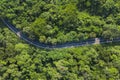 Aerial top view over mountain rural road in tropical rainforest with green tree Royalty Free Stock Photo