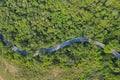 Aerial top view over mountain rural road in tropical rainforest with green tree Royalty Free Stock Photo