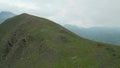 Aerial top view panorama solo caucasian woman hiker backpacker slowly hiking uphill in caucasus mountains. Sakori lake hiking