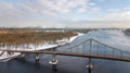 Aerial top view of pedestrian Park bridge in winter and Dnieper river from above, snow Kyiv cityscape, city of Kiev skyline Royalty Free Stock Photo