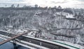 Aerial top view of pedestrian Park bridge in winter and Dnieper river from above, snow Kyiv cityscape, city of Kiev skyline Royalty Free Stock Photo