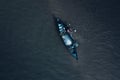 Aerial top view of a person on a fishing boat in a blue tranquil sea Royalty Free Stock Photo