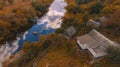 aerial top view point country side outskirts cabin house near river shore line in woods with orange foliage in autumn October day Royalty Free Stock Photo