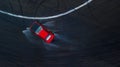 Aerial top view professional driver drifting car on wet race track, with water splash, red car.