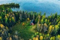 Aerial top view of red log cabin or cottage with sauna in spring forest by the lake in Finland Royalty Free Stock Photo