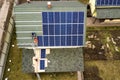 Aerial top view of residential house with team of workers installing solar photo voltaic panels system on roof. Renewable energy