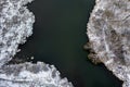 Aerial top view of river bend with snowy frozen shore and bare trees