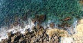 Aerial top view rocky shore and foamy waves