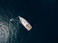 Aerial top view of a sailing yacht with a high mast floating on the water. Royalty Free Stock Photo