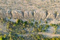 Aerial top view of sand quarry with green trees, slope of open pit.