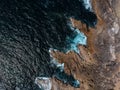 Aerial top view of sea waves hitting rocks on the beach with turquoise sea water. Amazing rock cliff seascape in the Portuguese co Royalty Free Stock Photo