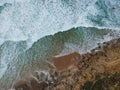 Aerial top view of sea waves hitting rocks on the beach with turquoise sea water. Amazing rock cliff seascape in the Portuguese co