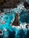 Aerial top view of sea waves hitting rocks on the beach with turquoise sea water. Amazing rock cliff seascape in the Portuguese co