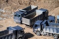 Aerial top view of several dump trucks unloading sand at a construction site. Industrial panorama. Royalty Free Stock Photo