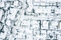 Aerial view of snowy roofs and roads of suburban neighborhood