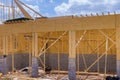 An aerial top view of stick built home under construction with wooden truss, post beam framework