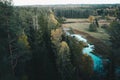 Aerial top view of summer trees in forest in rural Latvia whit blue woods river.