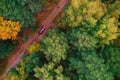 Aerial top view travel drive autumn road in yellow forest, concept of trip by red car Royalty Free Stock Photo