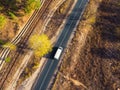 Aerial top view white modern delivery small shipment cargo courier van moving fast on motorway road city urban suburb Royalty Free Stock Photo