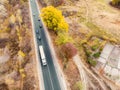 Aerial top view white semi trailer truck delivery shipment cargo courier moving fast on motorway road city urban suburb