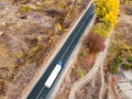 Aerial top view white semi trailer truck delivery shipment cargo courier moving fast on motorway road city urban suburb