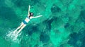 Aerial top view of woman snorkeling from above, girl snorkeler swimming in a clear tropical sea water with corals Royalty Free Stock Photo