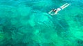 Aerial top view of woman snorkeling from above, girl snorkeler swimming in a clear tropical sea water with corals Royalty Free Stock Photo