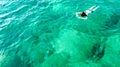 Aerial top view of woman snorkeling from above, girl snorkeler swimming in a clear tropical sea water with corals Royalty Free Stock Photo