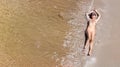 Aerial top view of young woman in bikini relaxing on sand tropical beach by sea and waves from above, girl on tropical island Royalty Free Stock Photo